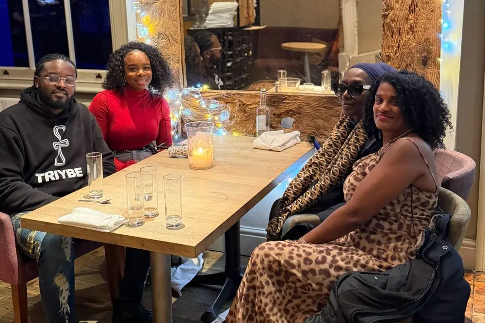Members of Team TRIYBE together at a table, one wearing a TRIYBE hoodie