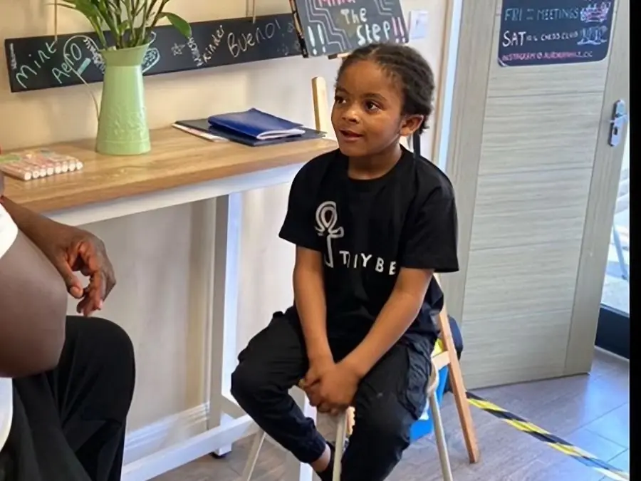 A TRIYBE Blazer in a TRIYBE T-shirt conducting an interview