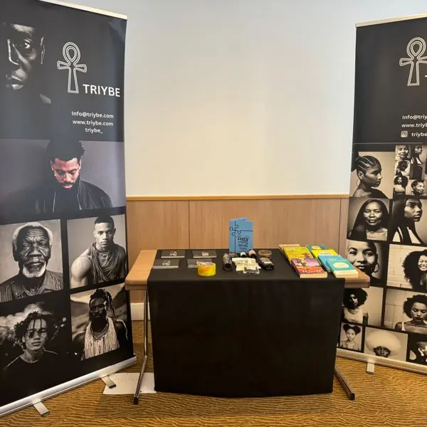 TRIYBE stall at the Every Little Thing Festival, supporting wellness and mental health, with TRIYBE banners, hair care products and books